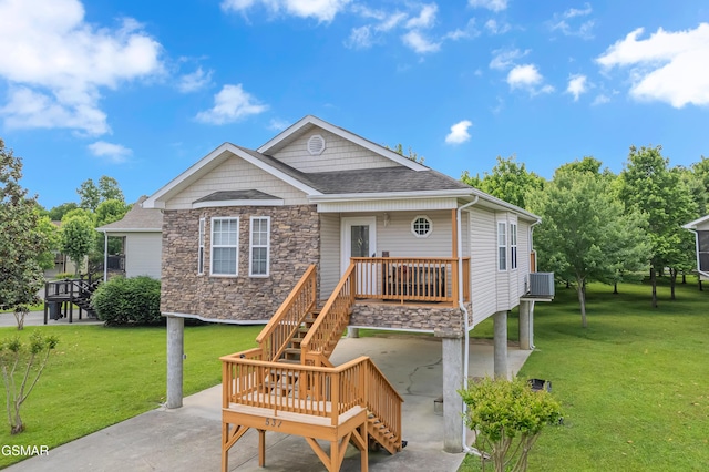 rear view of property featuring stairs, a lawn, stone siding, and a shingled roof