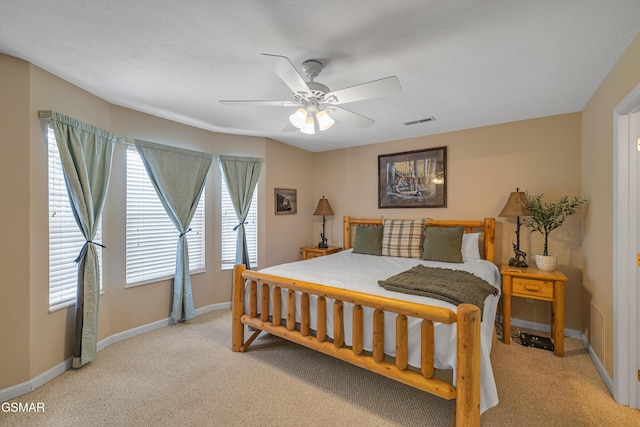 bedroom featuring light colored carpet, baseboards, and a ceiling fan