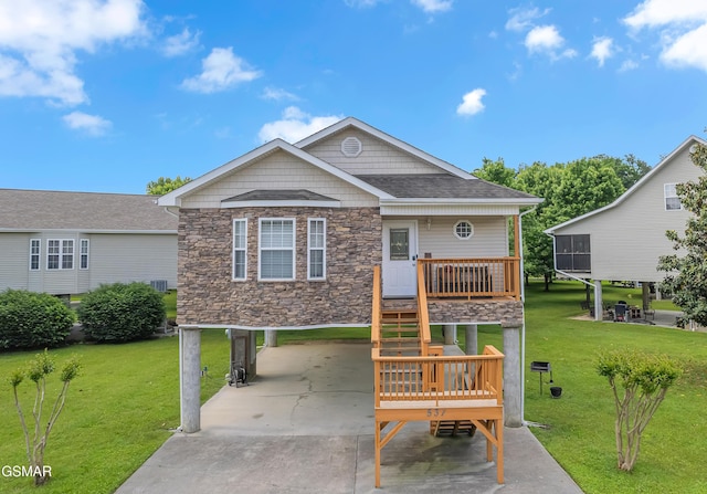 view of front of property featuring a carport, stone siding, a front lawn, and driveway