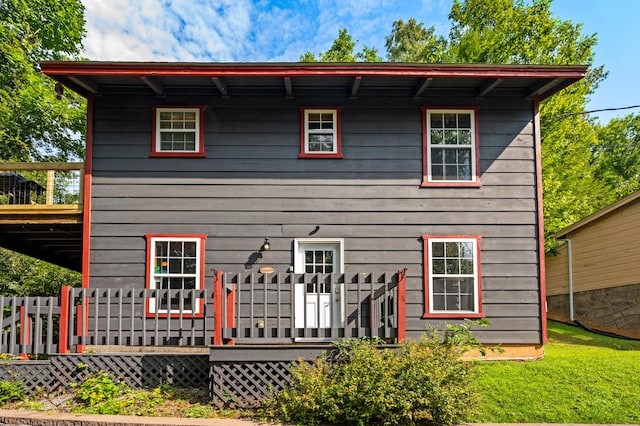 back of house featuring a lawn and a wooden deck