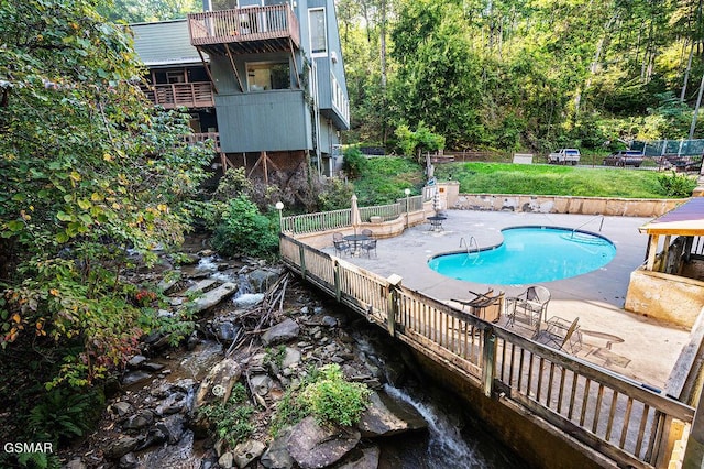 view of swimming pool featuring a patio area and a yard