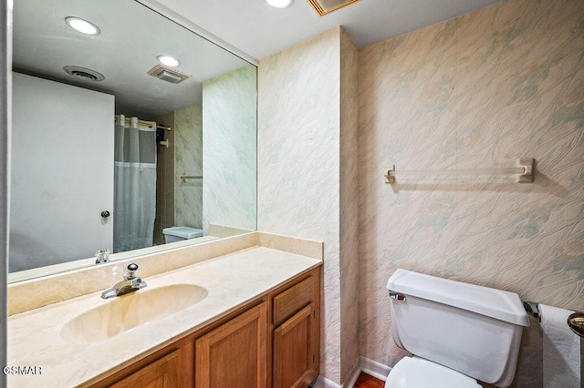 bathroom featuring curtained shower, toilet, and vanity