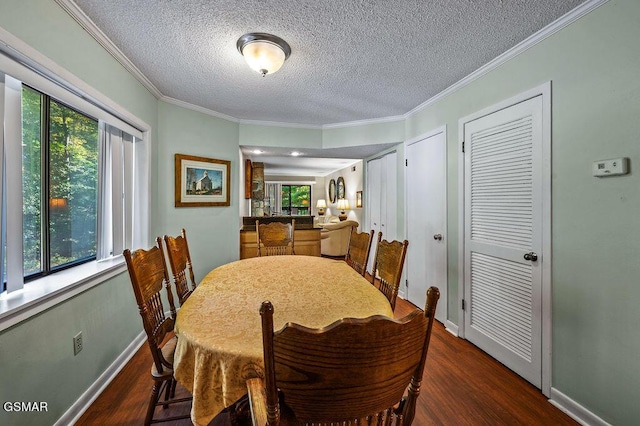 dining area featuring dark hardwood / wood-style floors, ornamental molding, and a textured ceiling