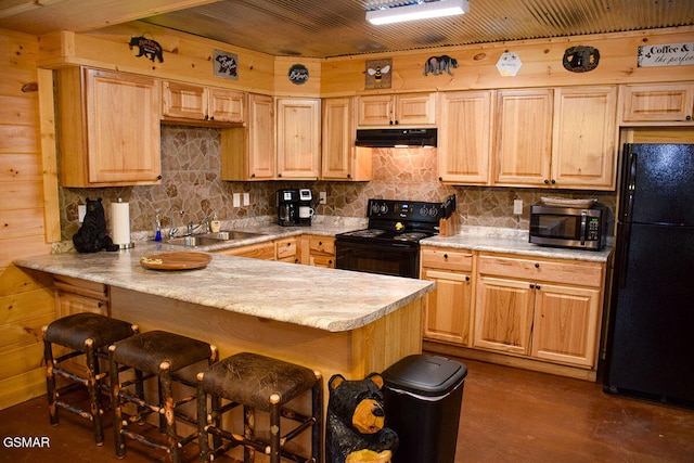 kitchen with tasteful backsplash, a sink, black appliances, a peninsula, and under cabinet range hood