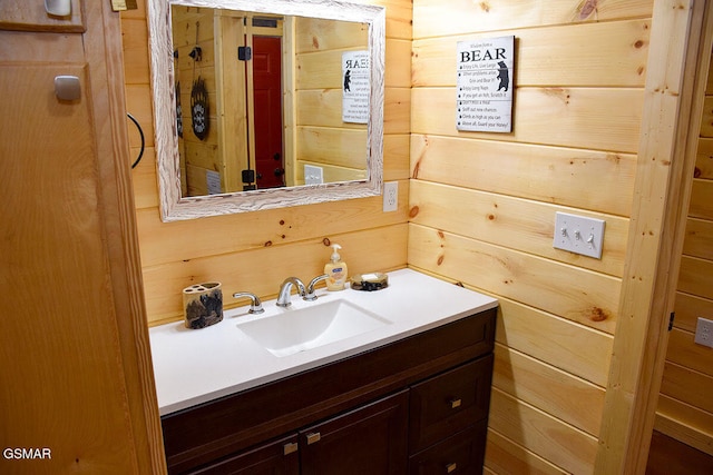 bathroom with vanity and wooden walls
