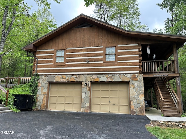 1529 Hidden Cir, Sevierville, TN 37876 - view of front of property featuring stone siding, stairway, log exterior, an attached garage, and driveway