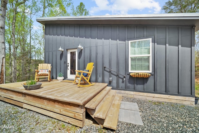 rear view of property with board and batten siding and a wooden deck