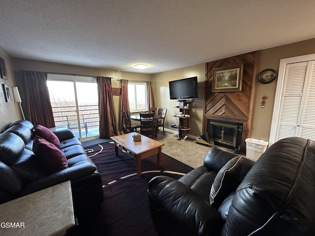 living room featuring carpet, a textured ceiling, and a fireplace