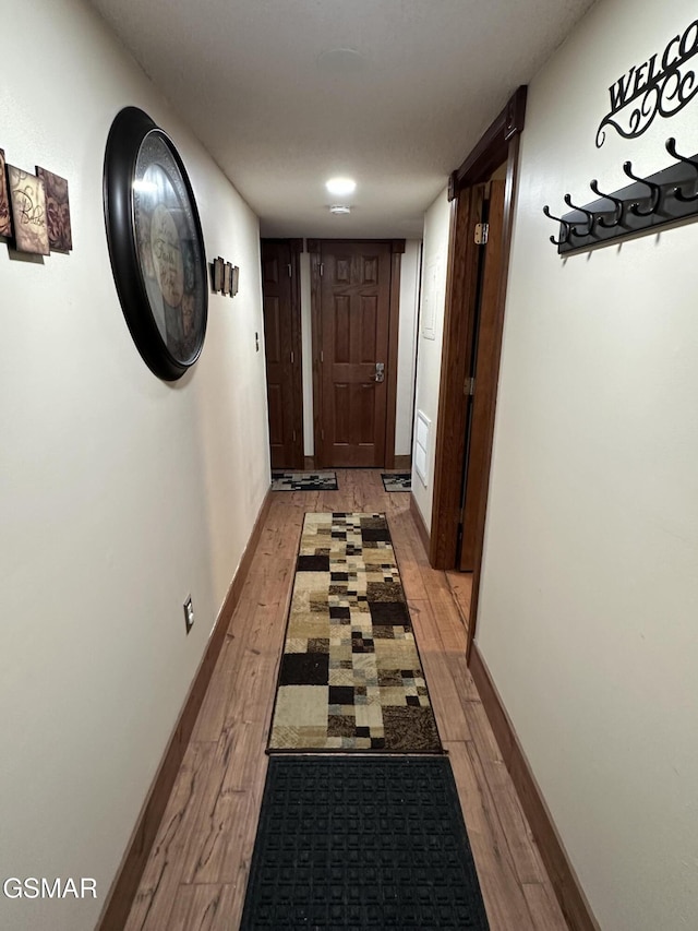 hallway with light hardwood / wood-style floors