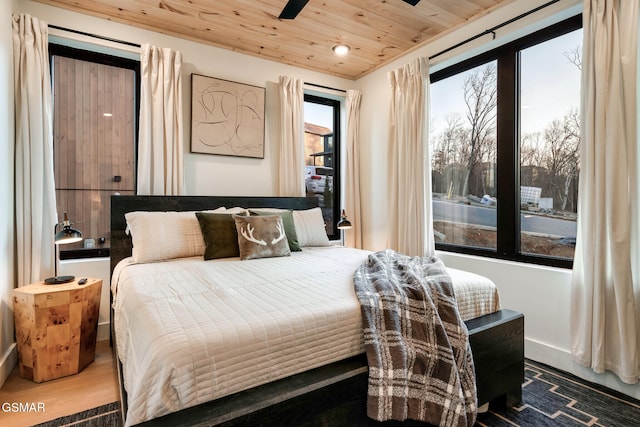 bedroom with multiple windows, wood ceiling, and wood finished floors