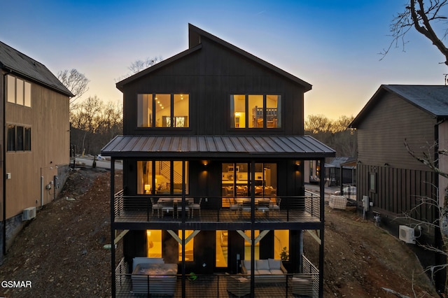 back of house at dusk with a standing seam roof and metal roof