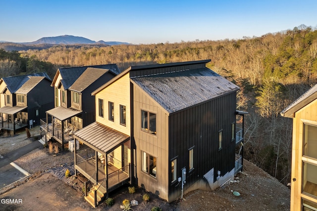 rear view of property with a standing seam roof and a mountain view
