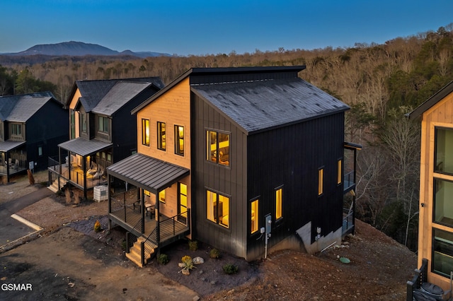 back of house featuring a standing seam roof, metal roof, and a mountain view