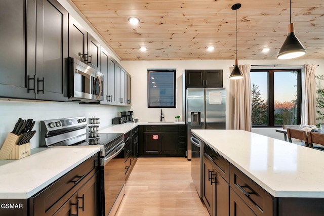 kitchen with a sink, light countertops, light wood-style flooring, stainless steel appliances, and wood ceiling