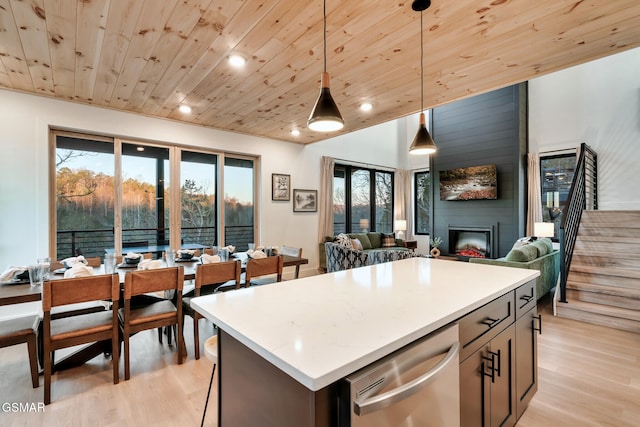 kitchen with wood ceiling, decorative light fixtures, a fireplace, light wood-type flooring, and open floor plan