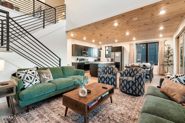 living room with recessed lighting, stairs, wood ceiling, and light wood-type flooring