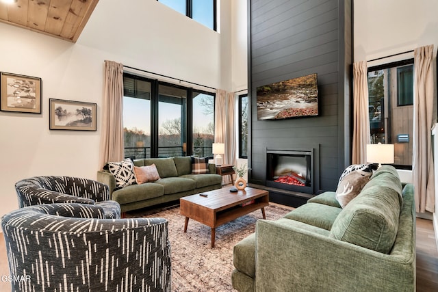 living area featuring a high ceiling, wood finished floors, and a fireplace