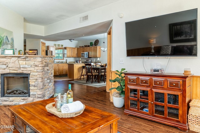 living room with a fireplace and dark wood-type flooring