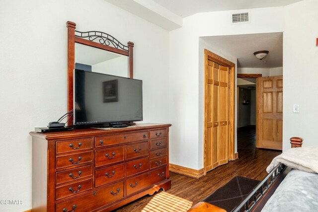 bedroom with a closet and dark hardwood / wood-style floors