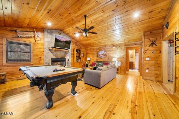 playroom featuring vaulted ceiling, wooden walls, a fireplace, wooden ceiling, and light wood-type flooring