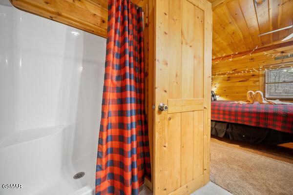 bathroom featuring wood ceiling, wooden walls, and a shower with shower curtain