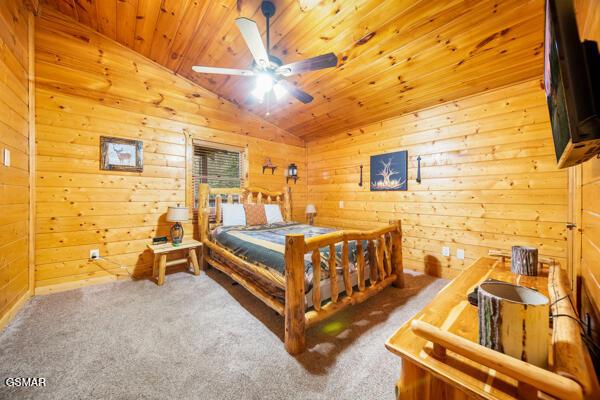 carpeted bedroom featuring vaulted ceiling, wooden ceiling, and wooden walls