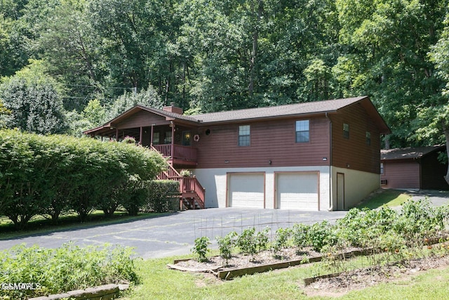 3188 Wears Dr, Sevierville, TN 37862 - view of front of home featuring driveway, a chimney, a vegetable garden, stairway, and a garage