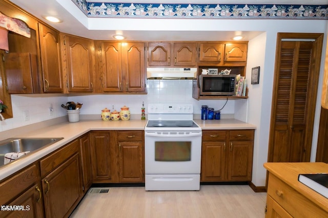 3188 Wears Dr, Sevierville, TN 37862 - kitchen with decorative backsplash, electric range, a sink, stainless steel microwave, and under cabinet range hood