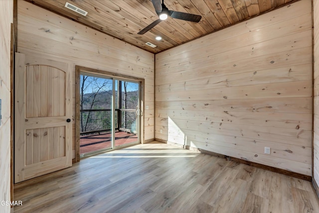 empty room with light hardwood / wood-style flooring, ceiling fan, wooden walls, and wood ceiling