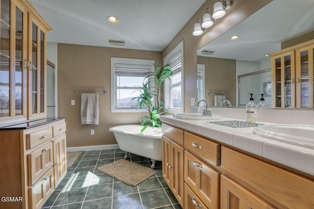 bathroom with visible vents, a sink, a shower stall, tile patterned flooring, and double vanity