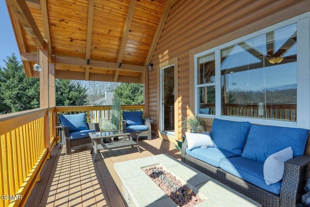 deck with an outdoor living space with a fire pit