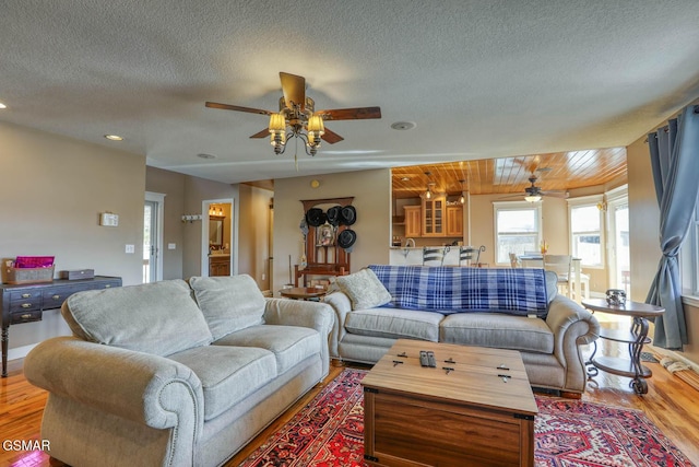 living room with recessed lighting, a textured ceiling, wood finished floors, and a ceiling fan