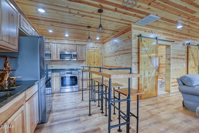 kitchen with light wood finished floors, appliances with stainless steel finishes, wood ceiling, and a barn door