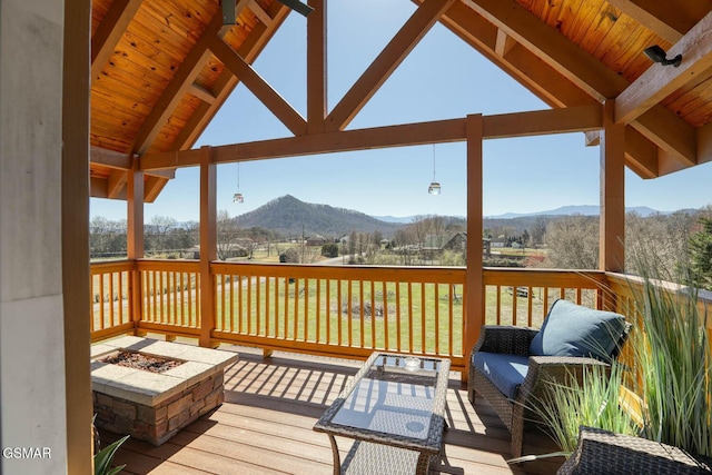 deck featuring a mountain view and an outdoor living space with a fire pit