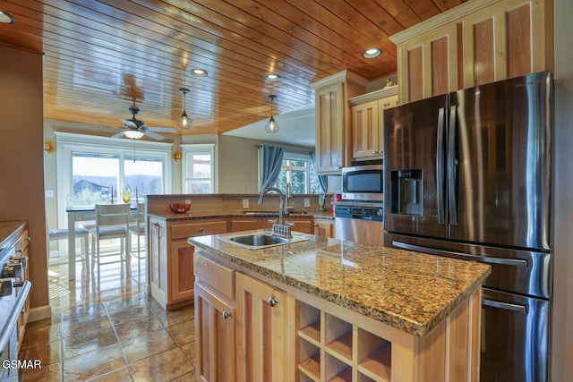 kitchen with a center island with sink, ceiling fan, a sink, wood ceiling, and appliances with stainless steel finishes