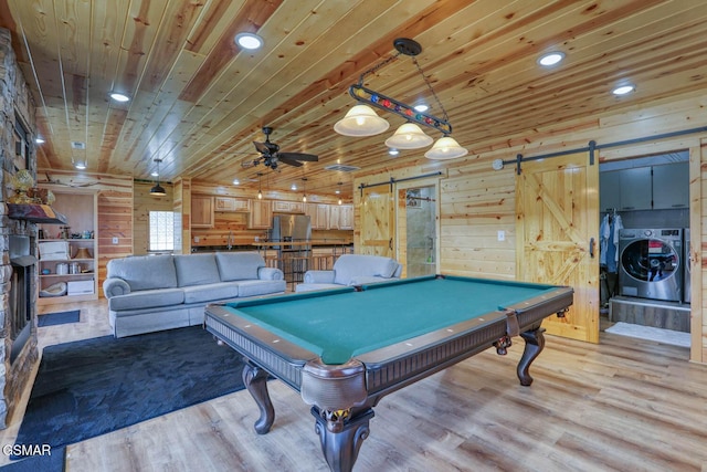 game room featuring a barn door, light wood-style flooring, washer / clothes dryer, and wooden ceiling