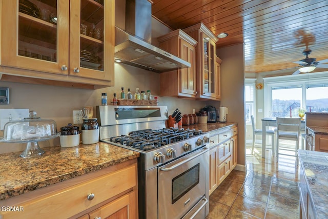 kitchen featuring light stone countertops, glass insert cabinets, wood ceiling, stainless steel gas range oven, and wall chimney range hood