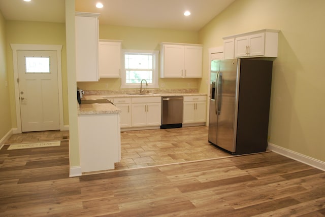 kitchen with white cabinetry, sink, light hardwood / wood-style floors, and appliances with stainless steel finishes