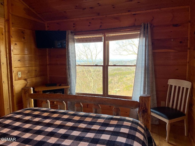 bedroom with wood walls and vaulted ceiling