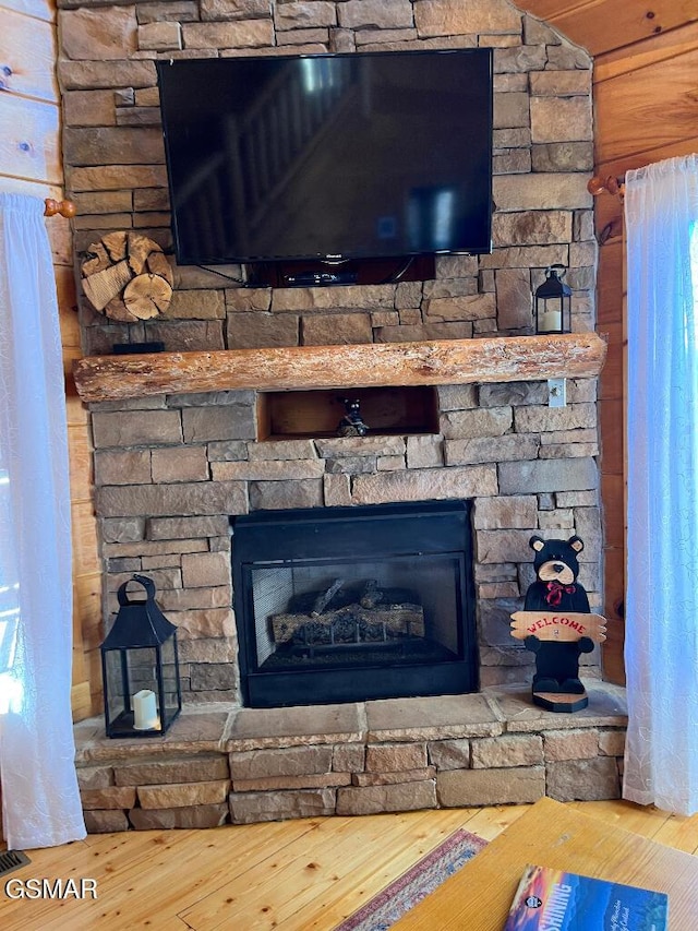 details with a stone fireplace and hardwood / wood-style floors