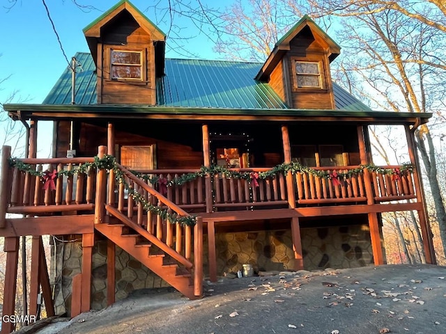 log home featuring covered porch