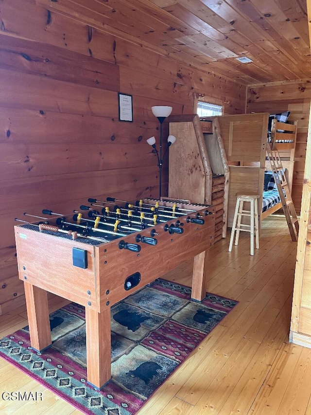 game room featuring hardwood / wood-style flooring, wood ceiling, and wooden walls