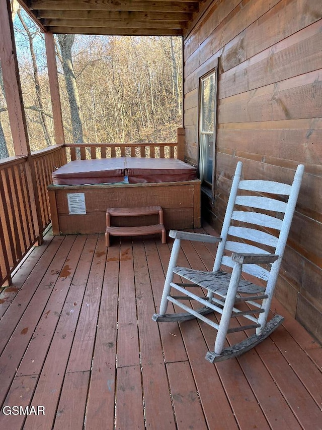 wooden deck with a covered hot tub