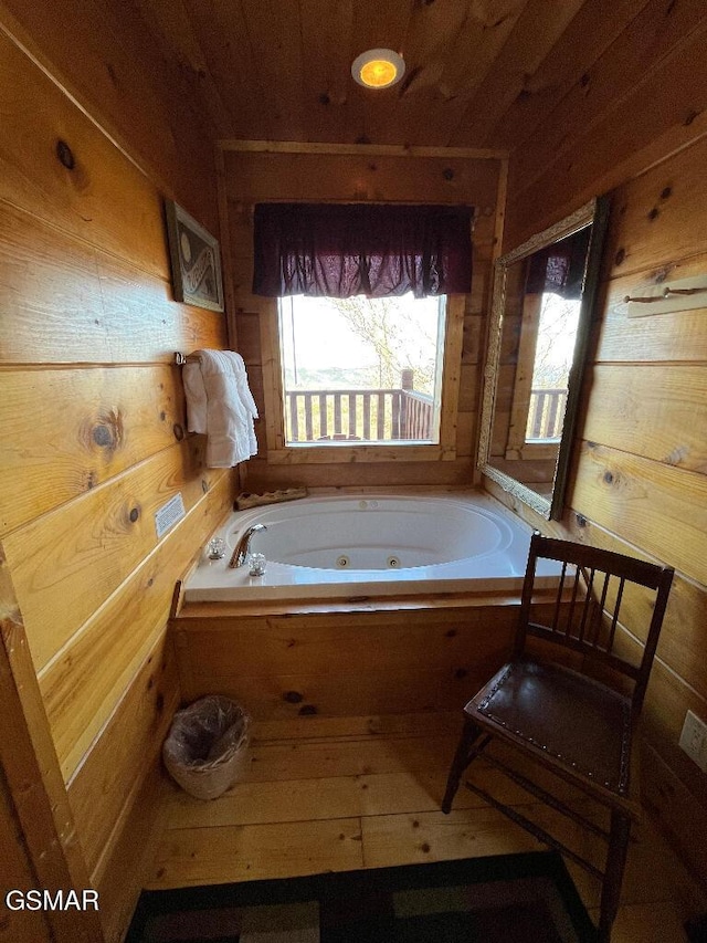 bathroom with wooden walls, a washtub, and wood ceiling