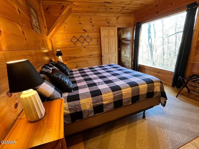 bedroom featuring lofted ceiling, wood ceiling, and wooden walls