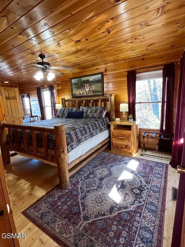 bedroom with hardwood / wood-style flooring, ceiling fan, wood walls, and wood ceiling