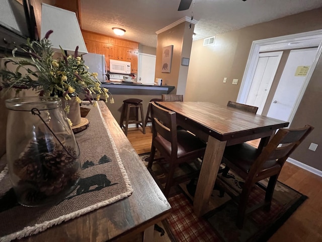 dining room with wood-type flooring and a textured ceiling