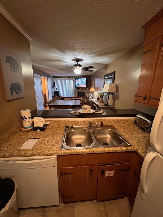 kitchen with dishwasher, sink, ceiling fan, kitchen peninsula, and a textured ceiling