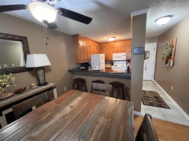 dining space with ceiling fan and a textured ceiling