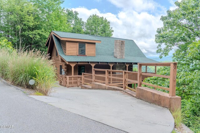 1910 E Mountain View Way, Sevierville, TN 37876 - view of front facade with a porch, a shingled roof, log exterior, and concrete driveway